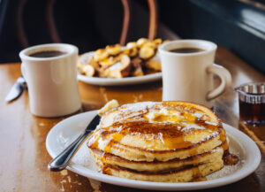pancakes with syrup on table